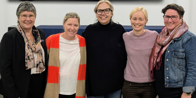 Group photo of four Christ the King School community members and guest speaker Rebecca Sparrow standing together after the friendship seminar at Fair Play Kitchen.