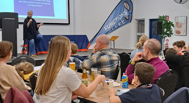 Families enjoy dinner and conversation while listening to Rebecca Sparrow share friendship insights during the Christ the King School community seminar.