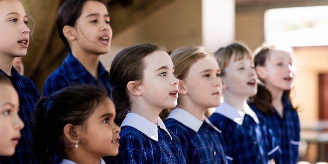 Students singing in a choir outdoors