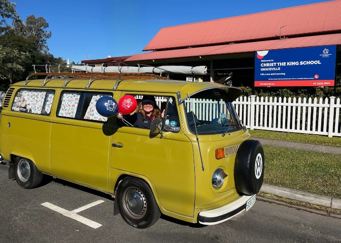 The yellow VW Kombi driven by Mrs Suzannah Halpin, who is holding one blue and one red CTK School balloon.